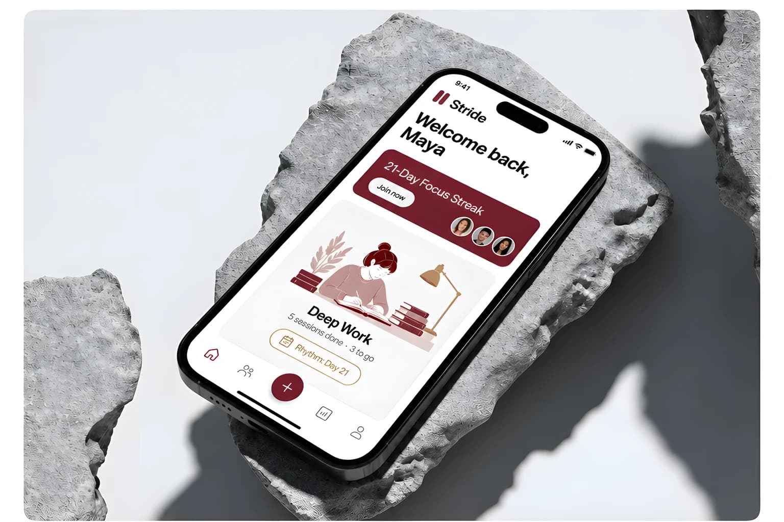 A phone lying on a grey stone slab showing the Stride home screen: a white surface, the Stride wordmark, the greeting Welcome back Maya, an oxblood 21-Day Focus Streak banner with a Join now button, and a Deep Work card reading 5 sessions done, 3 to go.